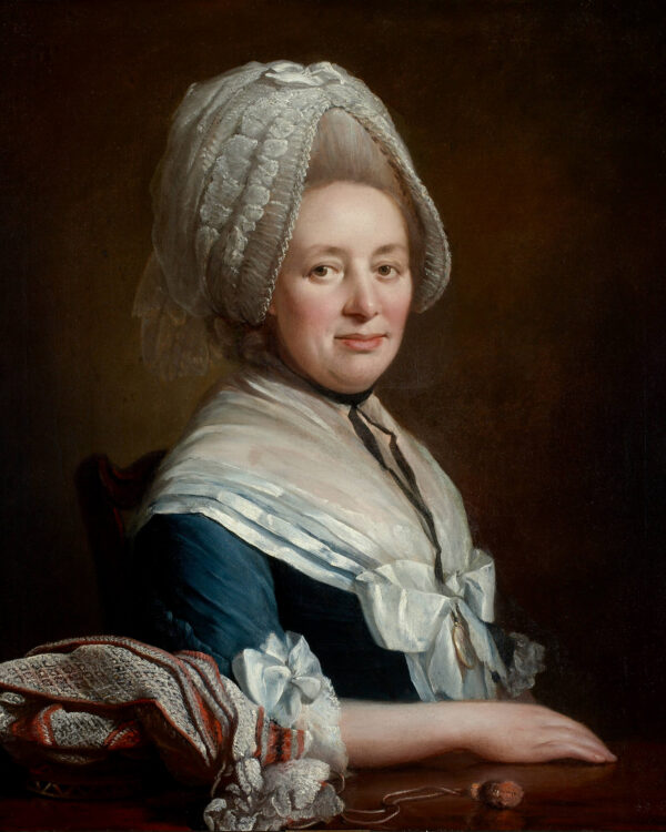 Elisabeth Ourry seated at a table in a blue dress 